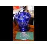 A 32cm high blue overlay glass vase and cover