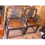 A pair of carved wooden antique Chinese armchairs
