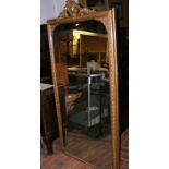 An antique gilt framed hall mirror with shaped sur