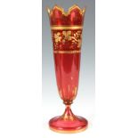 A LATE 19TH CENTURY BOHEMIAN RUBY GLASS GILT DECORATED SLENDER VASE with gothic edge top and