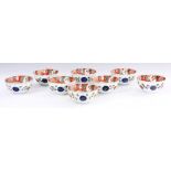 A SET OF EIGHT CHINESE RED FAMILLE ROSE RICE BOWLS; decorated with brightly coloured panels of red