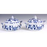 A PAIR OF MEISSEN BLUE AND WHITE TUREENS with raised side handles and swirled finials, decorated