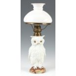 A LATE 19TH CENTURY PORCELAIN OIL LAMP MODELLED AS AN OWL with brass burner and white glass shade,