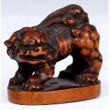 A JAPANESE BOXWOOD NETSUKE of a Foo Dog stood on plinth base, signed to underside.