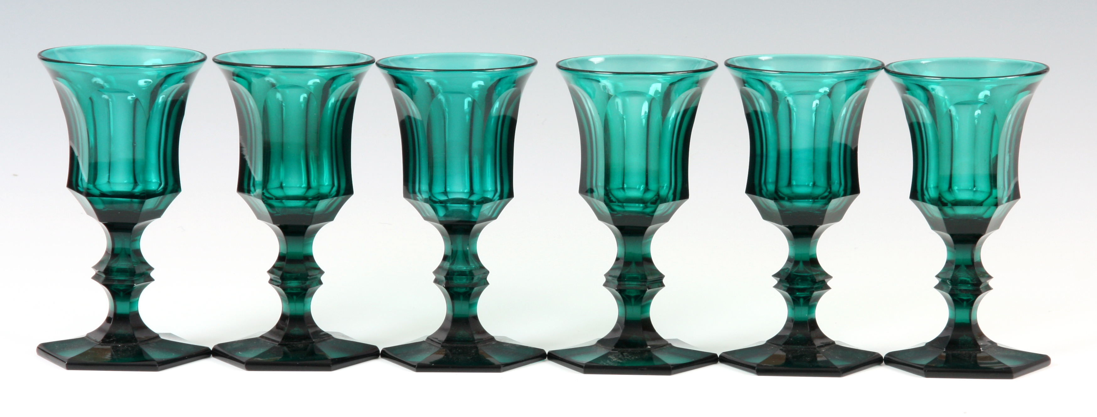 A SET OF SIX LATE 19TH CENTURY GREEN STAINED WINE GLASSES of chamfered hexagonal form 13cm high.