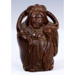 A JAPANESE HARWOOD NETSUKE of a woman in oriental dress.