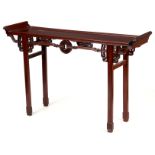 A CHINESE FREE STANDING HARDWOOD ALTAR TABLE of narrow proportions having an overhanging panelled