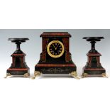 A LATE 19th CENTURY BLACK SLATE AND ROUGE MARBLE CLOCK SET the case stood on brass claw feet with