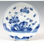 AN EARLY CHINESE PORCELAIN BLUE AND WHITE SHALLOW DISH with bird and tree-lined landscape decoration