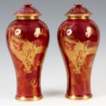 A PAIR OF WEDGWOOD RED LUSTRE VASES AND COVERS decorated with gilt painted dragons - stamps to the