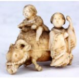 A JAPANESE IVORY SCULPTURE of a woman with son riding a buffalo.