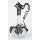 AN ART NOUVEAU STYLE SILVER MOUNTED CUT GLASS CLARET JUG decorated with grape vines and having a