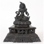 AN EARLY TIBETAN SEATED BRONZE BUDDHA with turquoise jewelled decoration, on a raised pierced plinth