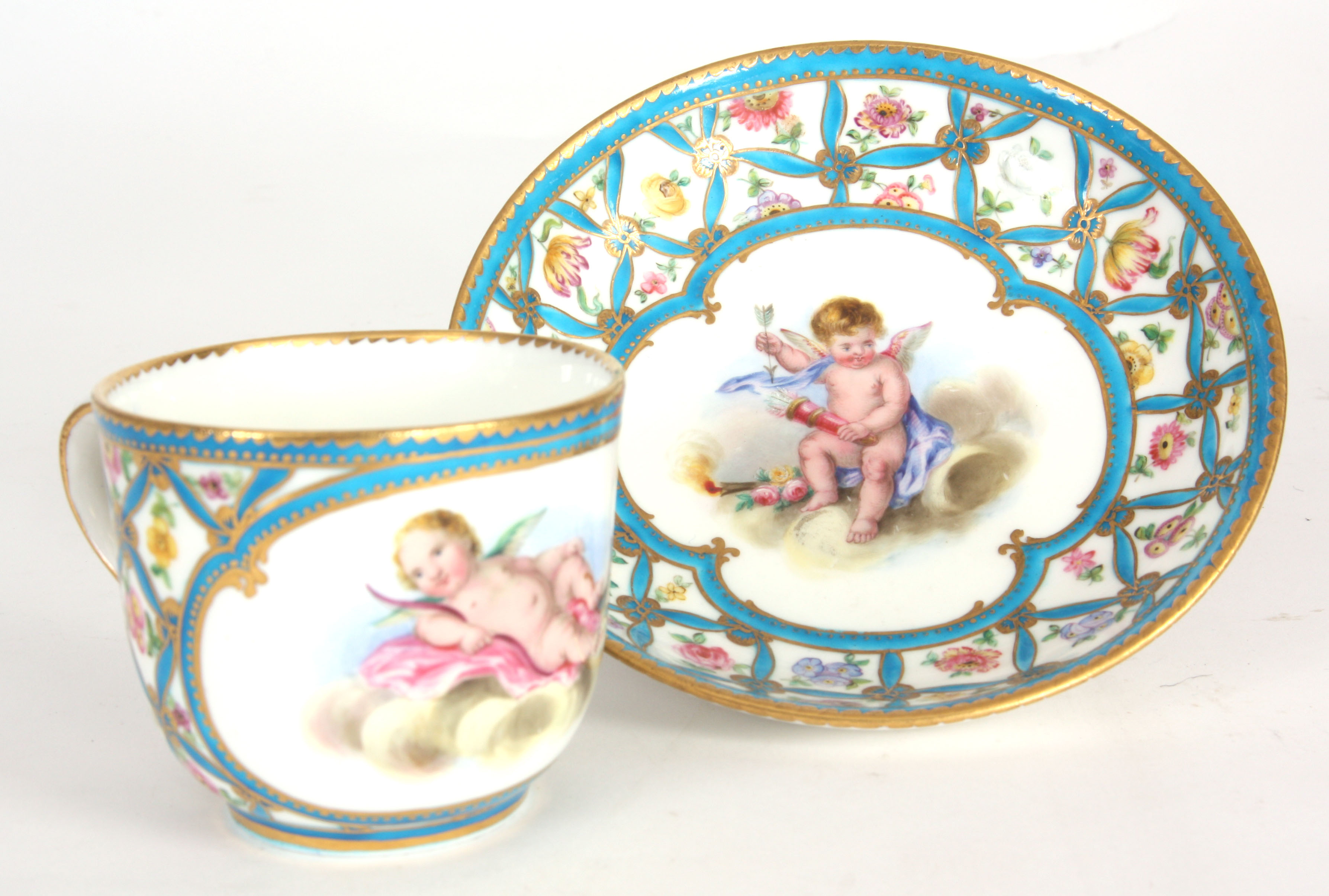 AN EARLY 19th CENTURY SERVES CUP AND SAUCER with flower and blue trellis decoration and painted