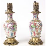 A PAIR OF EARLY 20TH CENTURY FAMILLE ROSE CANTONESE ORMOLU MOUNTED VASES CONVERTED TO LAMPS of