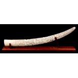 A 19TH CENTURY INDIAN CARVED IVORY TUSK with finely pierced and carved foliate scrollwork decoration