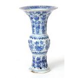 A  CHINESE BLUE AND WHITE TRUMPET VASE with a faceted body, decorated with flower sprays 23cm high.