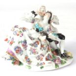 A MID 18TH CENTURY MEISSEN FIGURE GROUP of two lovers sat amongst flowers, brightly decorated with a