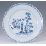 AN 18TH CENTURY ENGLISH DELFT CHARGER decorated with a flower and trees 34.5cm diameter