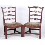 A PAIR OF MID 18TH CENTURY MAHOGANY SIDE CHAIRS with carved ladder backs and dished drop in tapestry