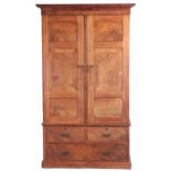 A LATE 19TH CENTURY ARTS AND CRAFTS STYLE FLAMED OAK WARDROBE IN THE MANOR OF THE COTSWOLD SCHOOL