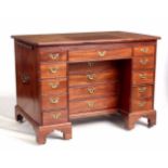 A GEORGE II MAHOGANY ARCHITECT’S DESK OF GENEROUS SIZE the hinged ratcheted top with release