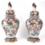 A LARGE PAIR OF LATE 17th CENTURY JAPANESE IMARI LIDED VASES of balluster form with three panels