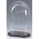 A 19th CENTURY OVAL GLASS DOME ON EBONISED BASE 52cm high