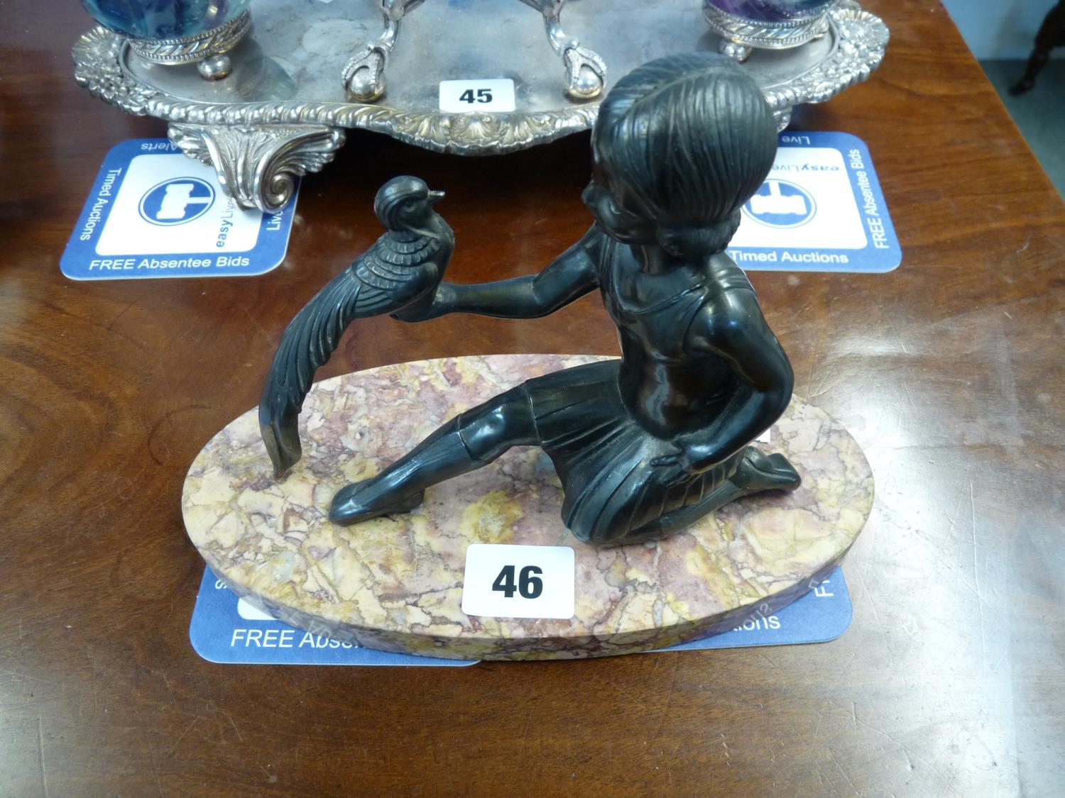 Art Deco Spelter figure of a girl with game bird mounted on oval marble base