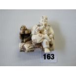 Early 20thC Ivory Netsuke of a Wise man smoking opium on a log with Wise man, character mark to