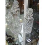 Silver rimmed cut glass decanter and another decanter with white metal rim