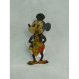 A rare German lithograph tin plate toy of Mickey Mouse, playing a saxophone and symbols, printed