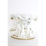 Moores Bros Co. porcelain Tazza of Cupid Cherubs forging arrows with floral encrusted stem, Gilded