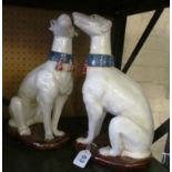 A pair of pottery Greyhounds seated with tassel collars