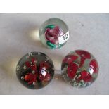 A lampwork paperweight and two flower paperweights.