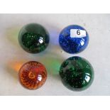 Two green bubble paperweights, blue and orange examples