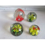 A fish paperweight and three flower and bird/insect paperweights