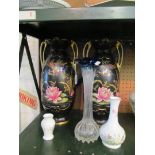 A pair of black vases and ornaments.
