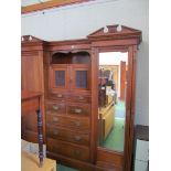 A large mahogany wardrobe with two side doors (one mirrored and one panelled), central cupboards and