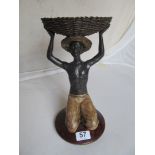 A bronze effect figure man holding basket