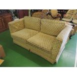 A two seater settee with oatmeal colour upholstery