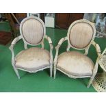 A pair of early 20th Century fauteuil with cream painted carved oval backs and tapered supports