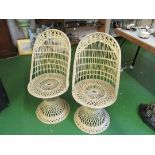 A pair of cane peacock style chairs on circular bases