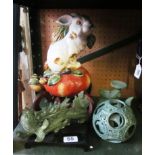 A pottery rabbit seated on a peach on oriental stand and two Jade style ornaments