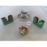 An enamel box with cufflinks two card holders, and a cup and saucer.