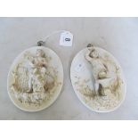 A pair of 19th Century oval French porcelain plaques cherubs