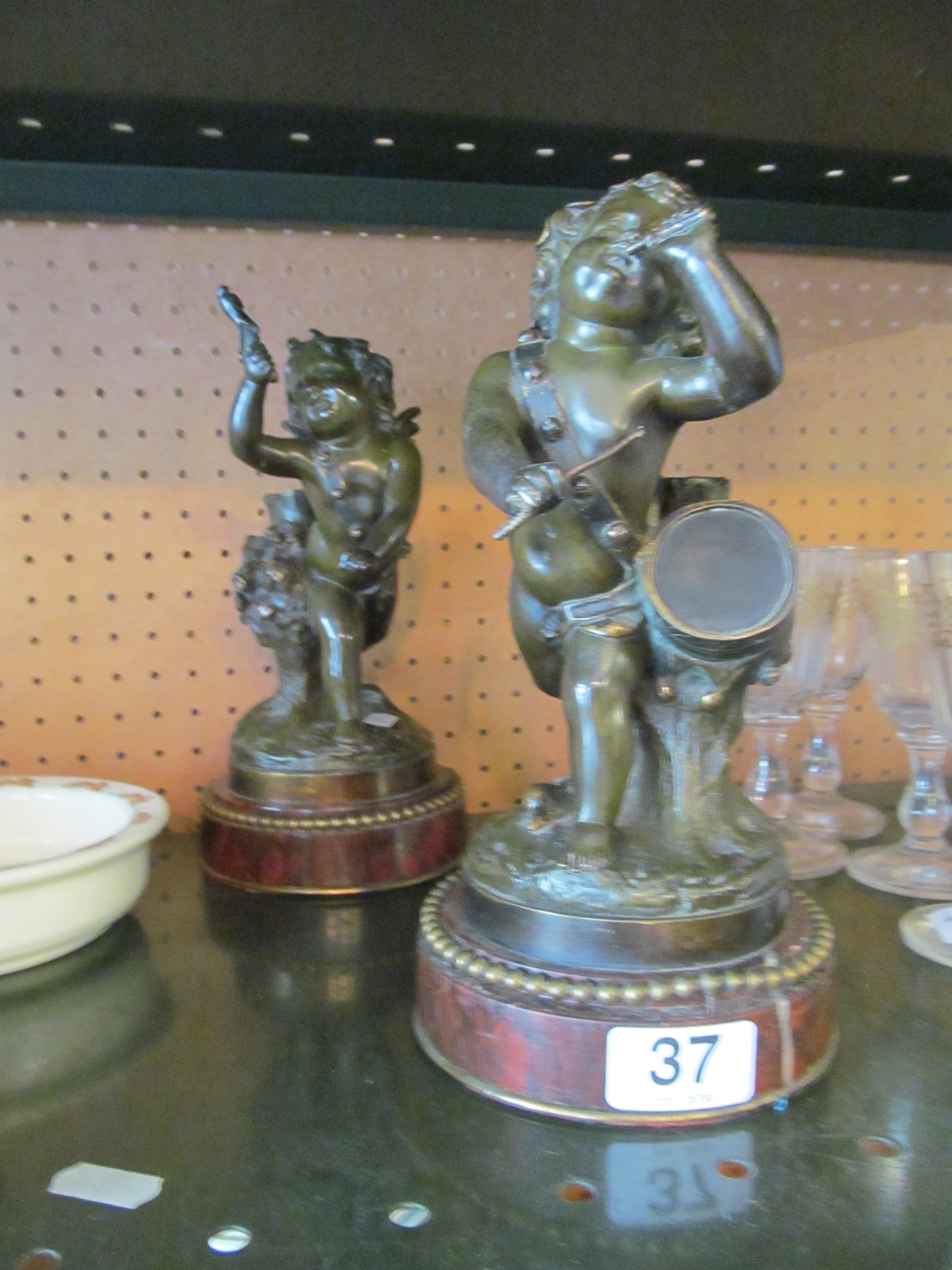 A pair of 19th Century French bronze cherubs one playing drum and carrying a pipe the other a