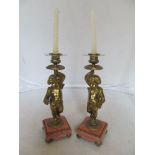 A pair of gilt bronze candlesticks cherubs on rouge marble base