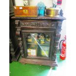 A carved oak cabinet with gallery, drawer and side glazed door