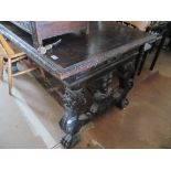 A carved oak table with drawers on shaped base with metal stretchers